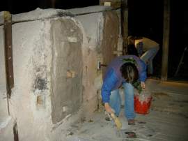 cleaning up the dust after the door is bricked and mudded and papered.
